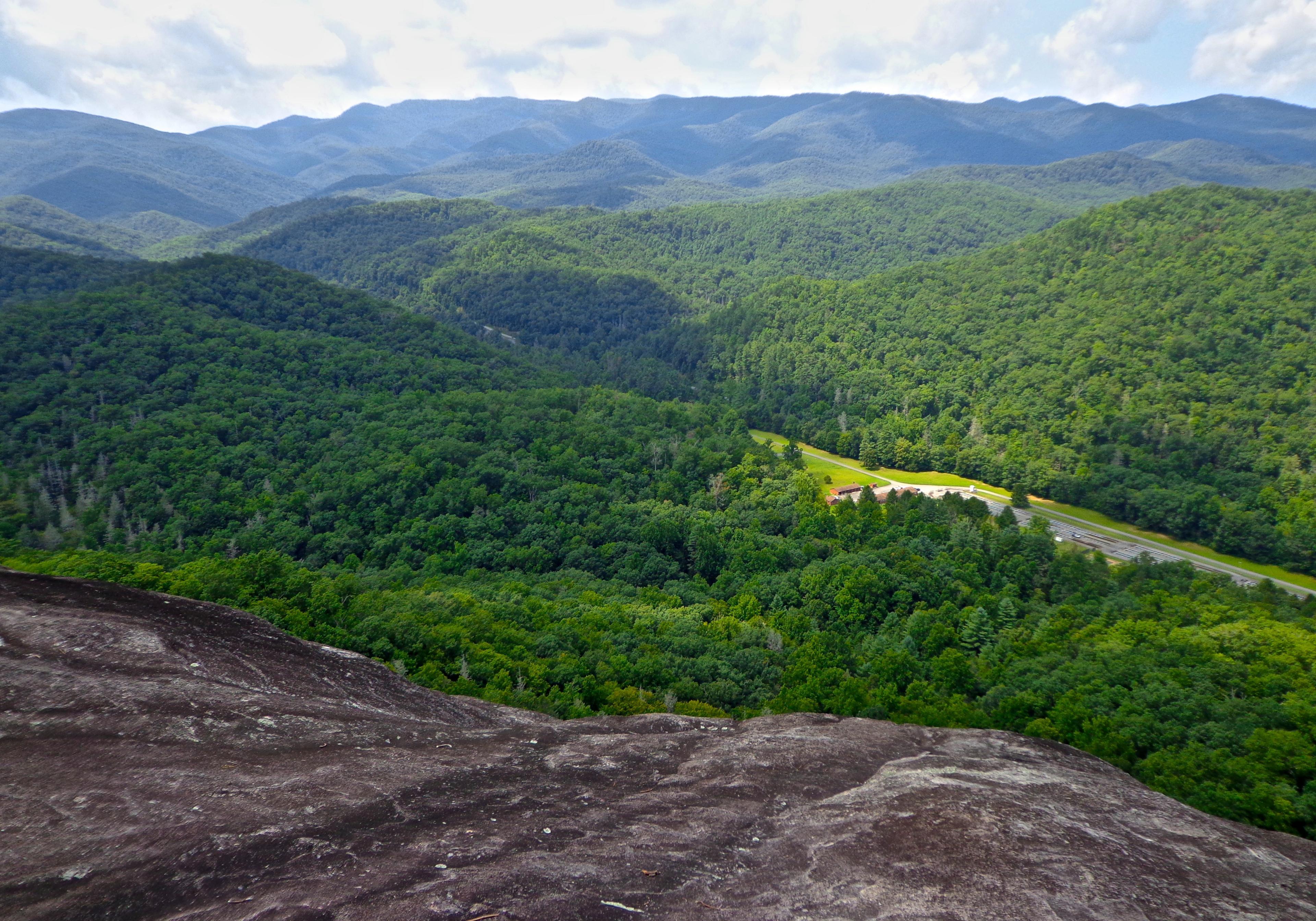 An aerial view of lush forest and rolling hills from John Rock Trail in Asheville