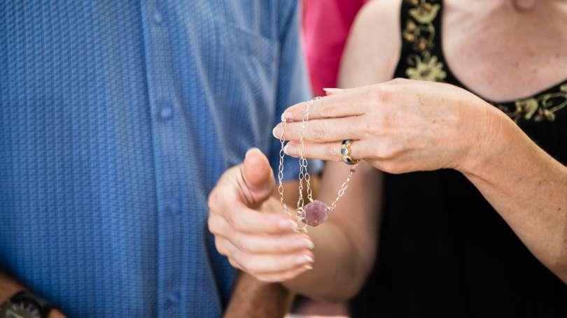 a person holds a necklace with a large purple stone in their hand in Asheville